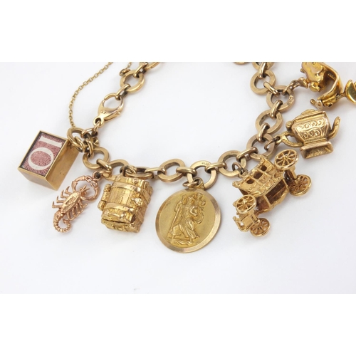 907 - 9ct gold charm bracelet with a selection of mostly gold charms including a squirrel, passport, binoc... 