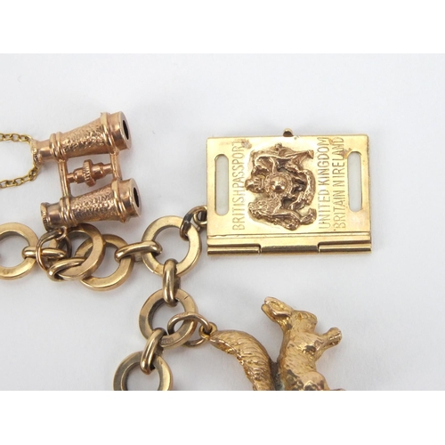 907 - 9ct gold charm bracelet with a selection of mostly gold charms including a squirrel, passport, binoc... 