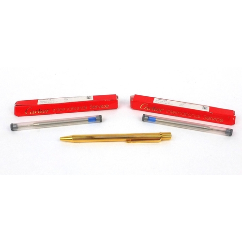 93 - Cartier gold plated ballpoint pen with two refills, the pen numbered 486556