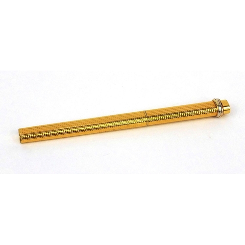 92 - Cartier gold plated ballpoint pen with engine turned decoration, numbered 2298301