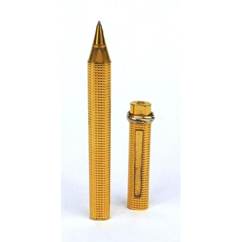 92 - Cartier gold plated ballpoint pen with engine turned decoration, numbered 2298301