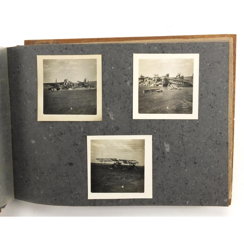 320 - Military interest black and white photographs housed in an album, including Ruins of planes, village... 