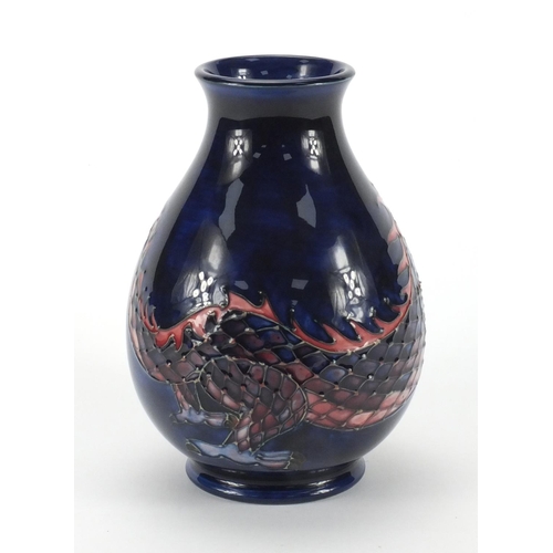 2164 - Moorcroft pottery baluster vase, hand painted and tube lined with a snarling scaly dragon onto a blu... 