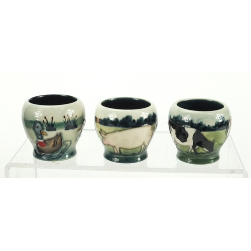 2165 - Set of six Moorcroft pottery egg cups with fitted box, each hand painted and tube lined with farmyar... 