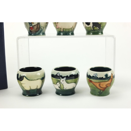 2165 - Set of six Moorcroft pottery egg cups with fitted box, each hand painted and tube lined with farmyar... 