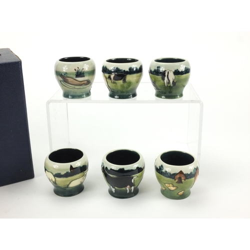 2165 - Set of six Moorcroft pottery egg cups with fitted box, each hand painted and tube lined with farmyar... 