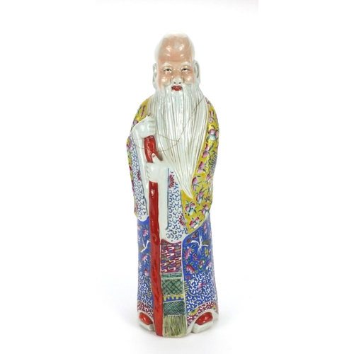 486 - Chinese porcelain figure of an elder holding a staff, wearing a robe hand painted with fruit, flower... 