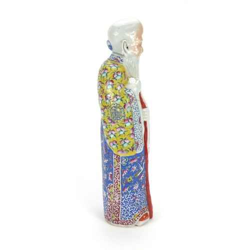 486 - Chinese porcelain figure of an elder holding a staff, wearing a robe hand painted with fruit, flower... 