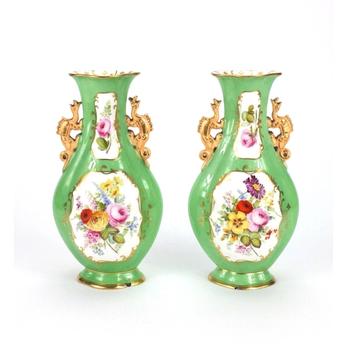 679 - Pair of Staffordshire vases with twin handles, hand painted with flowers onto a green ground, each 2... 