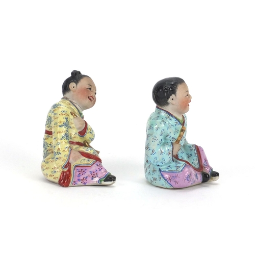 485 - Pair of Chinese seated figures of children, both hand painted in the famille rose palette, the large... 