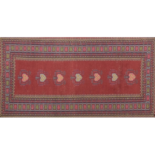 2075 - Rectangular Persian Bokhara rug having all over floral motifs onto a red ground, 173cm x 93cm