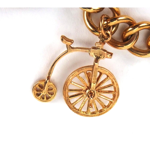 921 - 9ct gold charm bracelet with a selection of mostly gold charms including penny farthing, emergency t... 