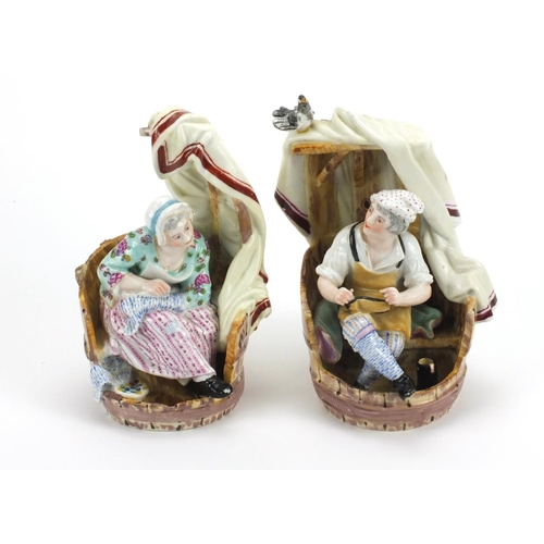 657 - Pair of 19th century continental porcelain figures sitting in barrels, cross sword marks to the base... 