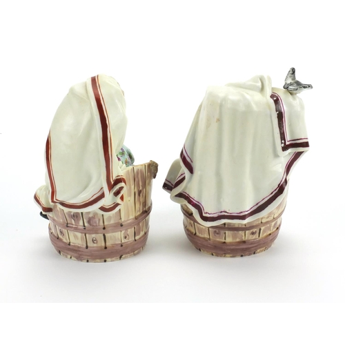 657 - Pair of 19th century continental porcelain figures sitting in barrels, cross sword marks to the base... 