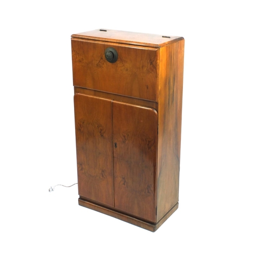 2064 - Art Deco walnut cocktail cabinet with mechanical action top, with mirrored interior above a pair of ... 