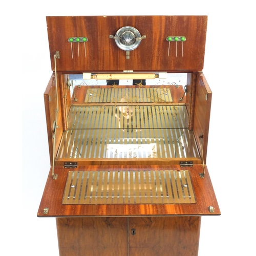 2064 - Art Deco walnut cocktail cabinet with mechanical action top, with mirrored interior above a pair of ... 