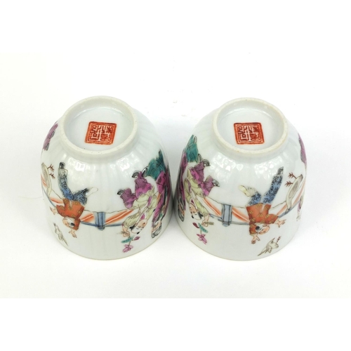 478 - Pair of Chinese porcelain tea cups, hand painted in the famille rose palette with court figures play... 