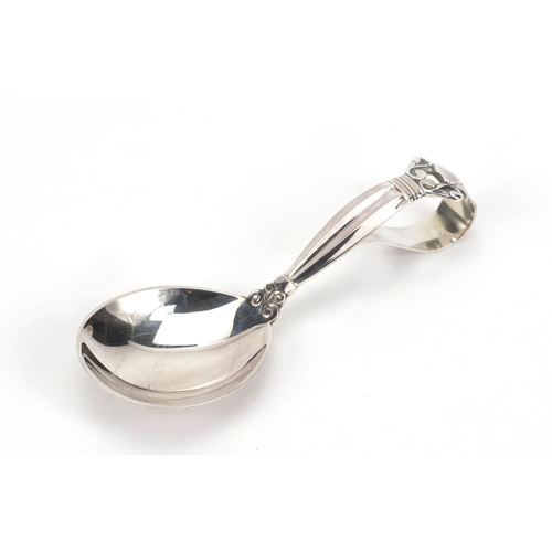 798 - Danish silver spoon with loop over handle, by Georg Jensen, the handle with stylised floral design, ... 