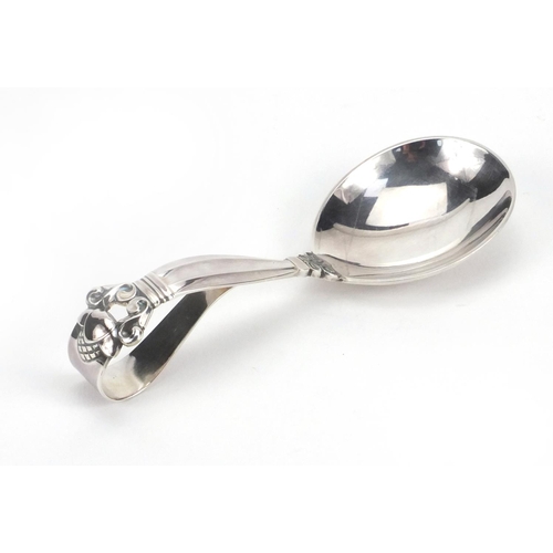 798 - Danish silver spoon with loop over handle, by Georg Jensen, the handle with stylised floral design, ... 