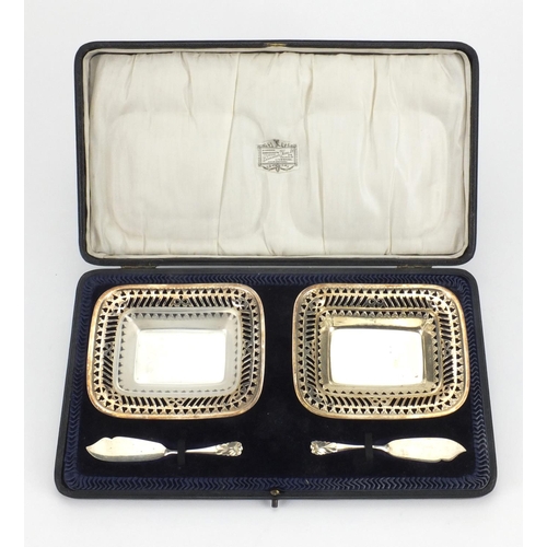 824 - Pair of silver butter dishes with pierced decoration and matching knives, housed in a fitted case, H... 