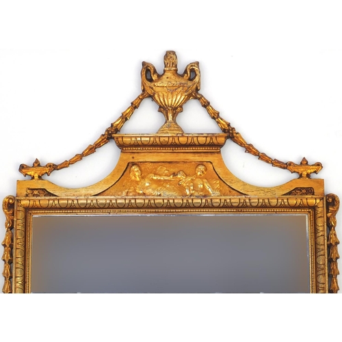 2022 - Rectangular gilt framed bevel edged mirror, decorated with urns, figures and swags, 114cm x 62.5cm
