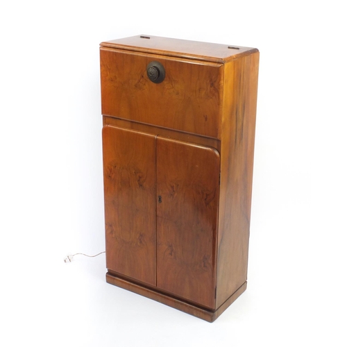 2064 - Art Deco walnut cocktail cabinet with mechanical action top, with mirrored interior above a pair of ... 