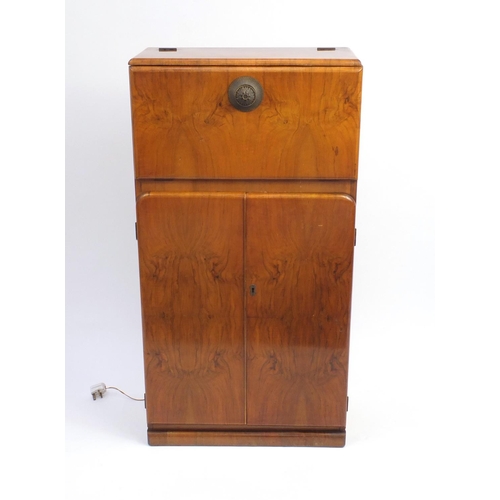 2064 - Art Deco walnut cocktail cabinet with mechanical action top, with mirrored interior above a pair of ... 