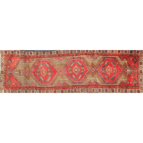 2061 - Rectangular Persian Arak carpet runner, having an all over geometric design onto a predominantly red... 