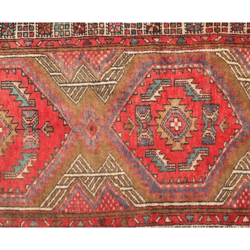 2061 - Rectangular Persian Arak carpet runner, having an all over geometric design onto a predominantly red... 