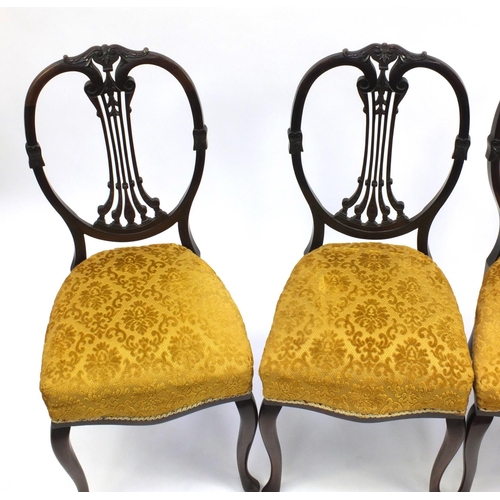 2033 - Set of four carved mahogany dining chairs with gold upholstered stuff over seats.  Each 96cm high