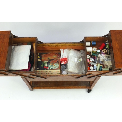 53 - Vintage oak cantilever sewing trolley and contents, 57cm high