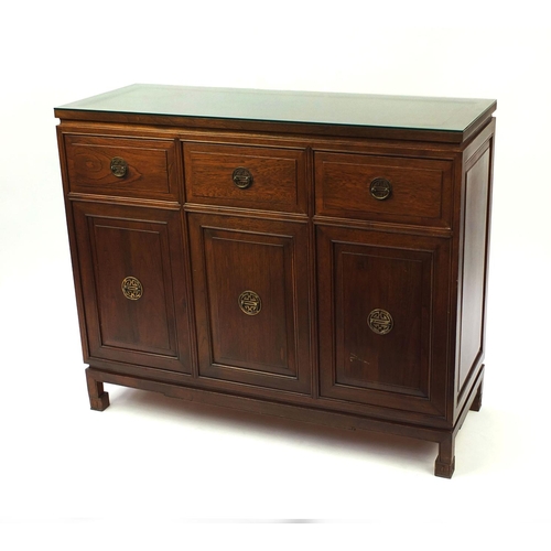 29 - Chinese rosewood sideboard fitted with three drawers above three cupboard doors, with glass top, 101... 