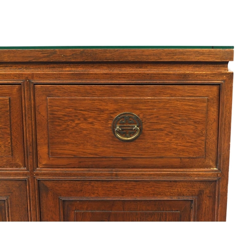 29 - Chinese rosewood sideboard fitted with three drawers above three cupboard doors, with glass top, 101... 
