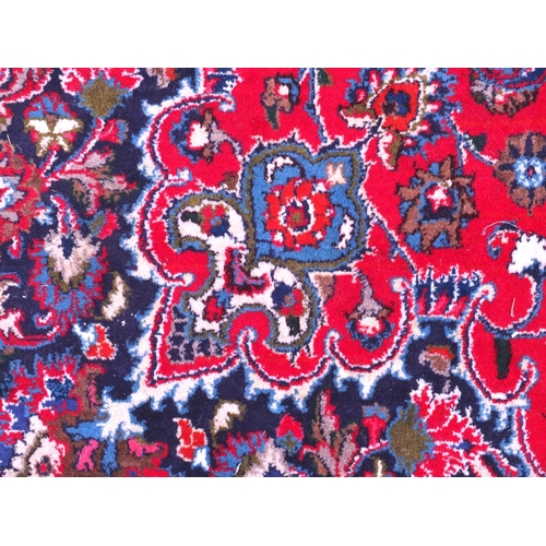 43 - Red and blue ground carpet with floral border and motifs, approximately 400cm x 300cm