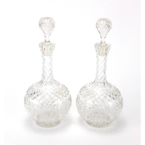 394 - Pair of cut glass decanters etched with flowers, each 30cm high