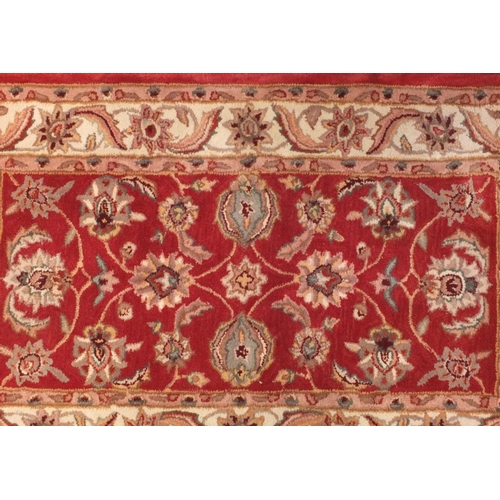 65 - Red and beige ground floral rug, 152cm x 91cm