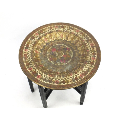 103 - Middle Eastern folding brass topped table, 51.5cm high x 60cm in diameter