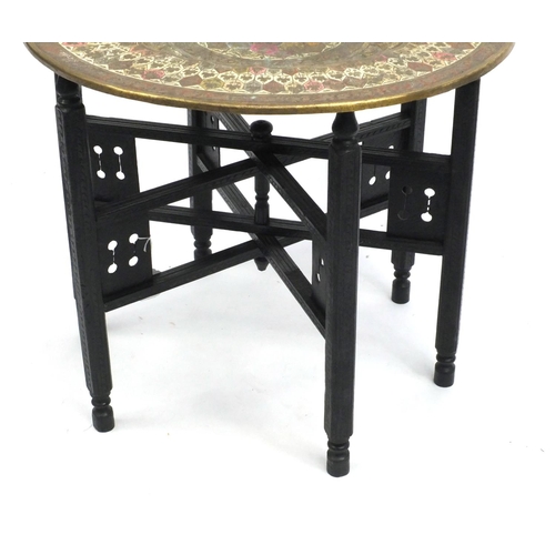 103 - Middle Eastern folding brass topped table, 51.5cm high x 60cm in diameter