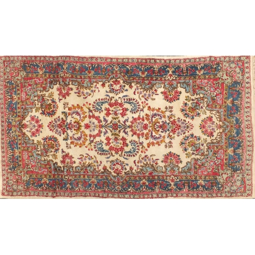 34 - Rectangular Persian Kerman rug with floral design onto a predominantly beige and pink ground, 225cm ... 
