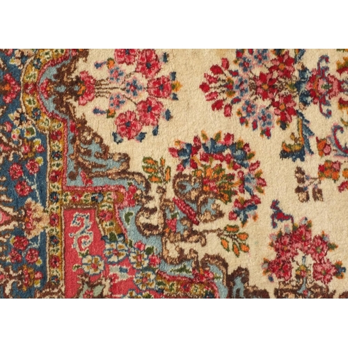 34 - Rectangular Persian Kerman rug with floral design onto a predominantly beige and pink ground, 225cm ... 