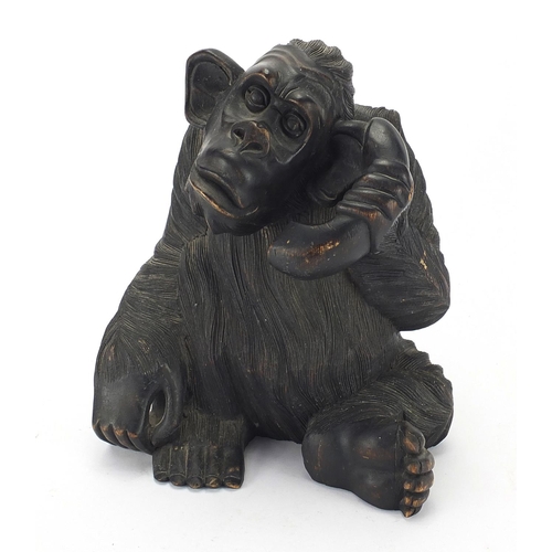 129 - Carved wooden chimpanzee with a telephone, 32cm H