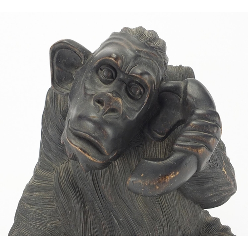 129 - Carved wooden chimpanzee with a telephone, 32cm H