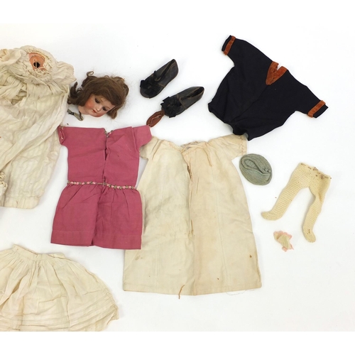 200 - Bisque head doll with open close eyes, with a selection of clothing including leather shoes