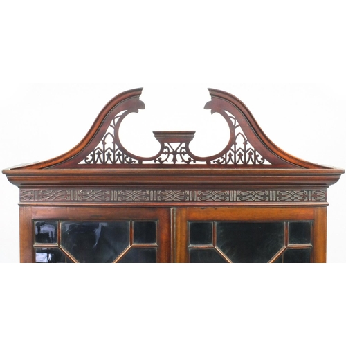 2003 - Chippendale style mahogany book case on stand, with swan neck pediment above a pair of astragal glaz... 