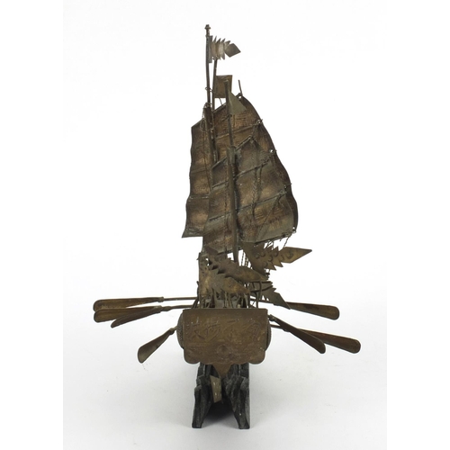 325 - Chinese silver coloured metal model of a junk raised on  wooden base, character marks to the reverse... 