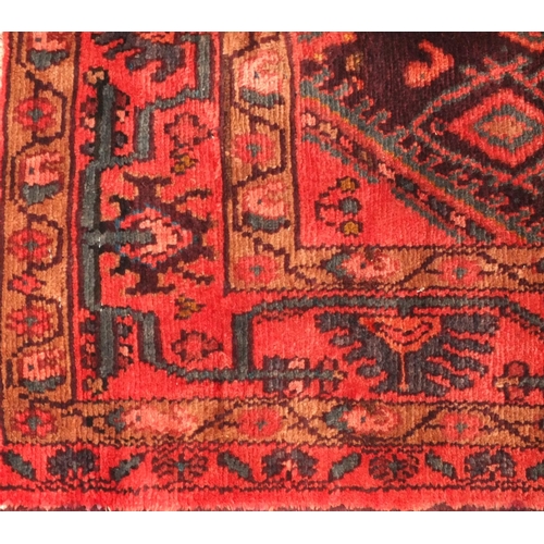 75 - Rectangular Persian Hamadan rug, the central field having all over floral motifs, onto an red and pu... 