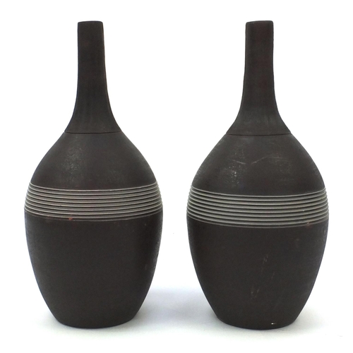 276 - Pair of long necked bottle vases with incised decoration, each 44.5cm high