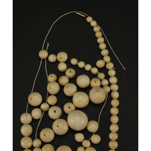 307A - Group of ivory beads with gold coloured metal clasp, the largest bead 2.4cm in D