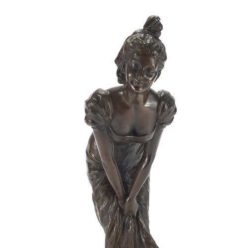 2098 - Bronze study of an Art Deco female holding her dress, raised on a circular marbleised base, signed E... 