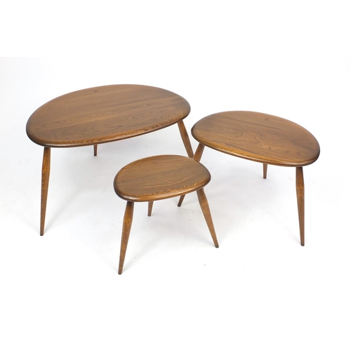 2028 - Ercol elm nest of three pebble tables, label to the inside of the larger, 40cm H